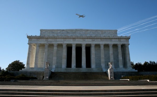Фотография здания с колоннадой на фоне голубого неба, демонстрирующая использование вертикальных линий в композиции фотографии