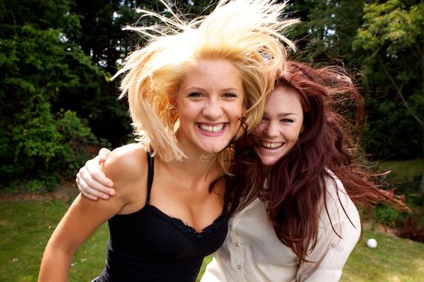 Фотография двух молодых женщин в движении с развевающимися на ветру волосами