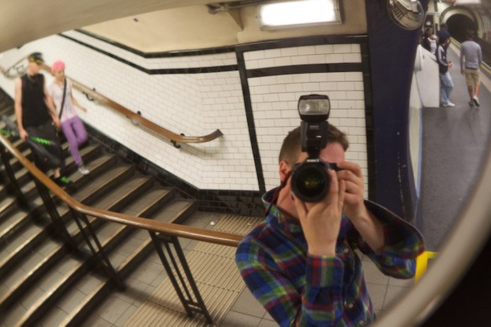 Фотограф, снимающий автопортрет в зеркале станции метро, демонстрирует использование динамического напряжения в композиции фотографии