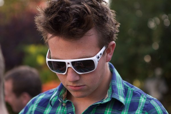Портрет молодого человека в солнцезащитных очках, демонстрирующий технику мягкого фона в фотографии