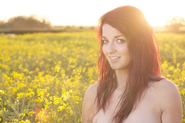 Фотография молодой женщины в поле желтых цветов демонстрирует редактирование с белой яркостью