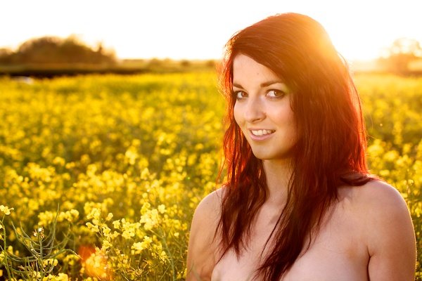 Фотография молодой женщины в поле желтых цветов демонстрирует редактирование с контрастом