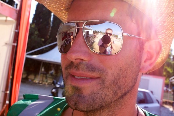 Мужчина в соломенной шляпе, отражающий фотографа в солнечных очках
