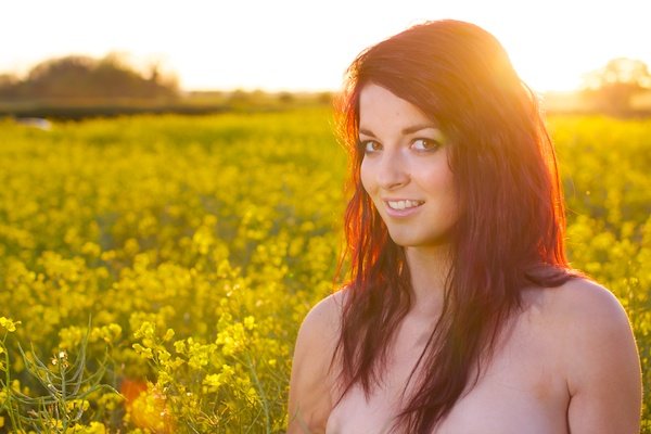 Фотография молодой женщины в поле желтых цветов демонстрирует редактирование с помощью насыщенности