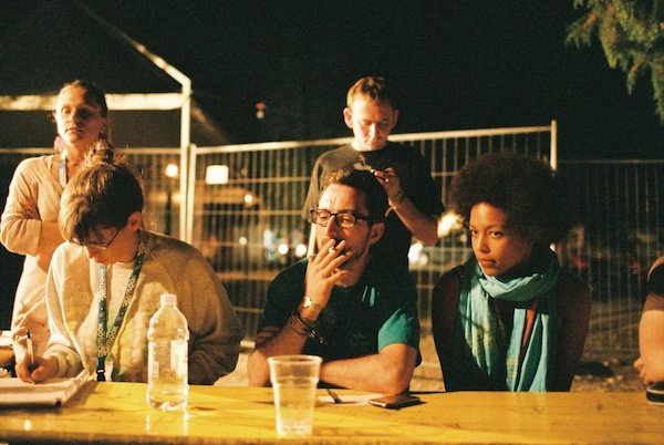 Фотография нескольких людей, сидящих на улице в темноте