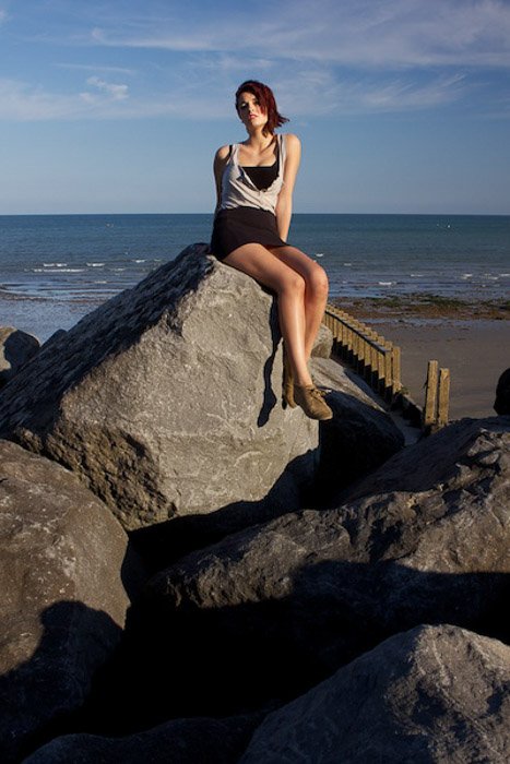Портрет женской модели, позирующей на камнях на пляже - интересные портреты