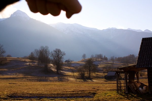 рука, загораживающая солнце на фоне словенских гор