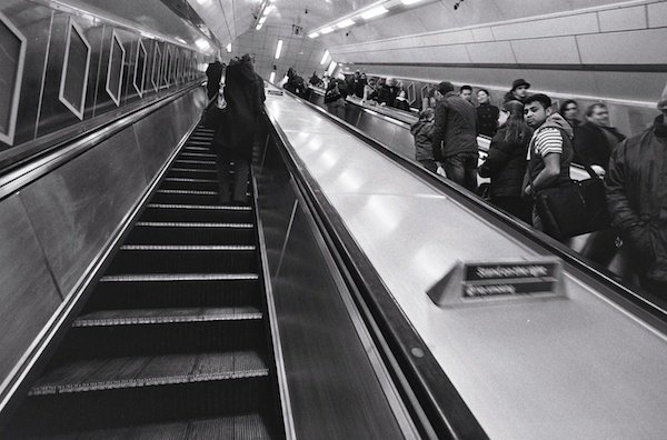 Люди едут на эскалаторах в Лондоне - черно-белая уличная фотография