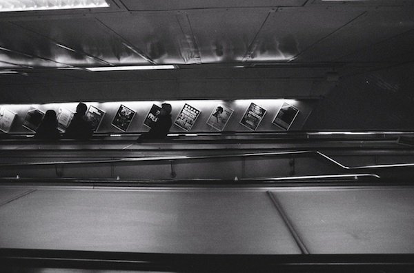 темное изображение людей на эскалаторах метро - черно-белая уличная фотография