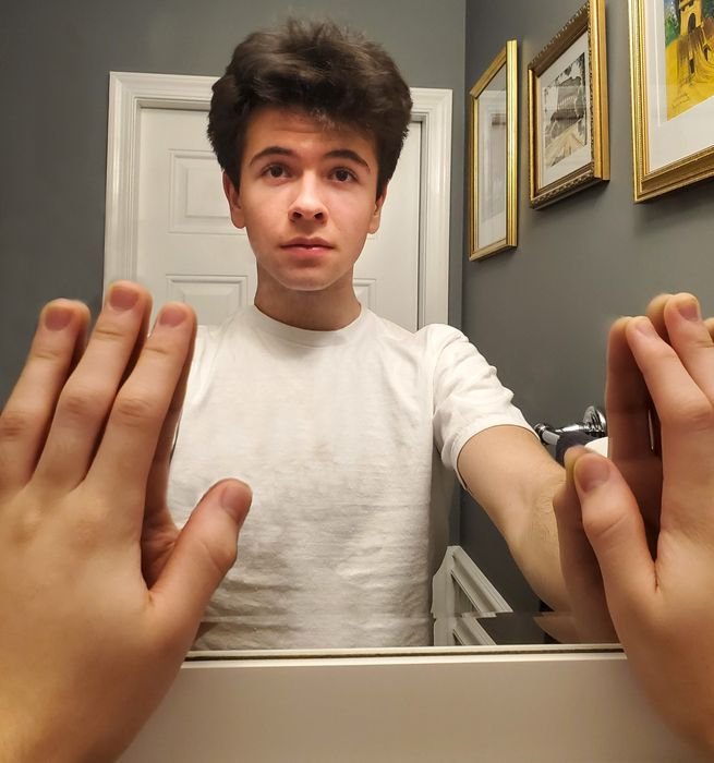 фото парня, трогающего зеркало обеими руками