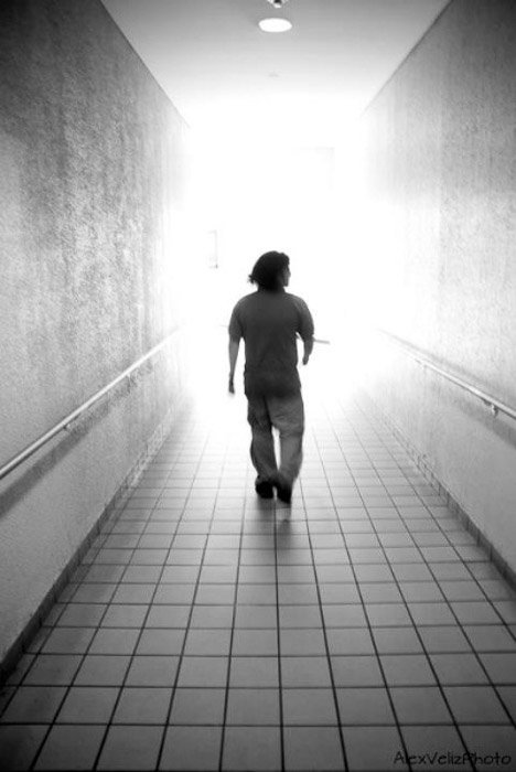 Черно-белая фотография мужчины, идущего по коридору