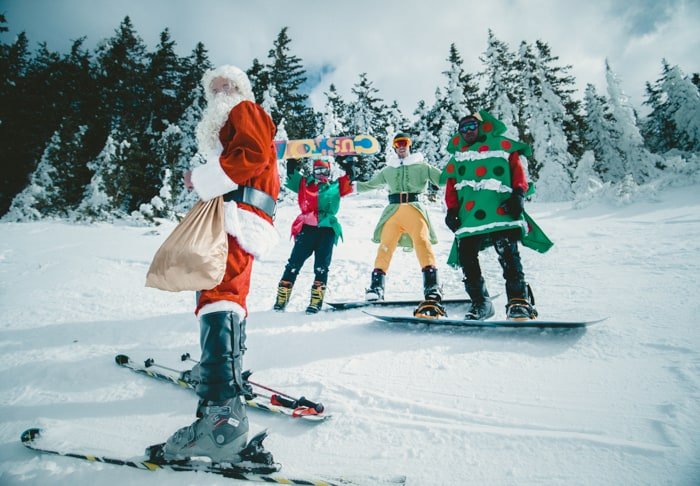 Санта и группа людей в рождественских нарядах катаются на коньках - уроки рождественской фотографии