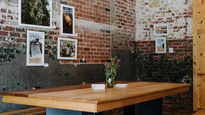 Деревянный стол в комнате с деревенским дизайном и фотография в рамке на стене
