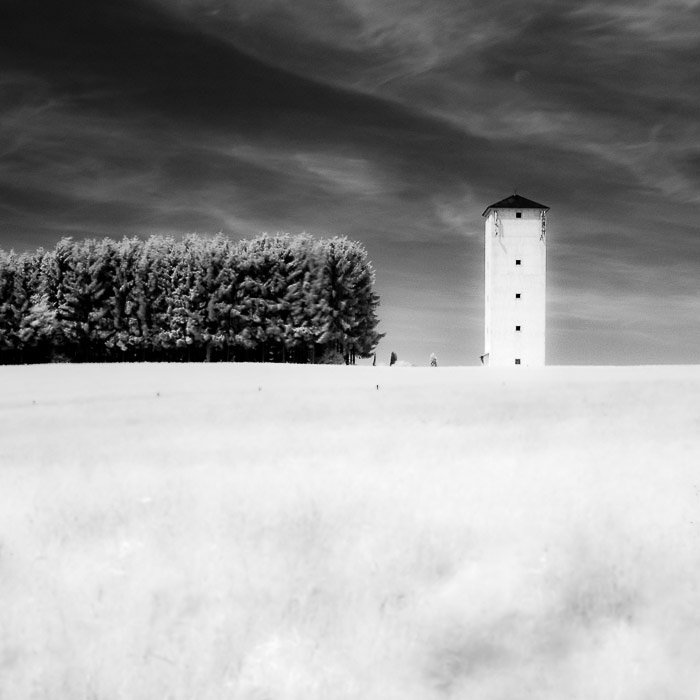 Инфракрасная фотография башни в сельской местности, демонстрирующая симметрию в фотографии