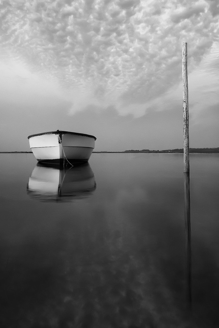 Изображение лодки в воде, демонстрирующее хороший черно-белый контраст