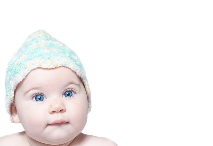 High key portrait of baby wearing hat