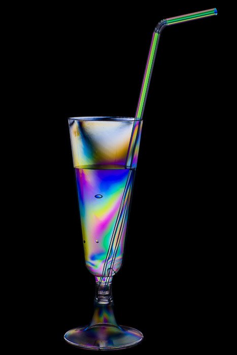 Эффект радуги на пластиковом коктейльном стакане и соломинке.