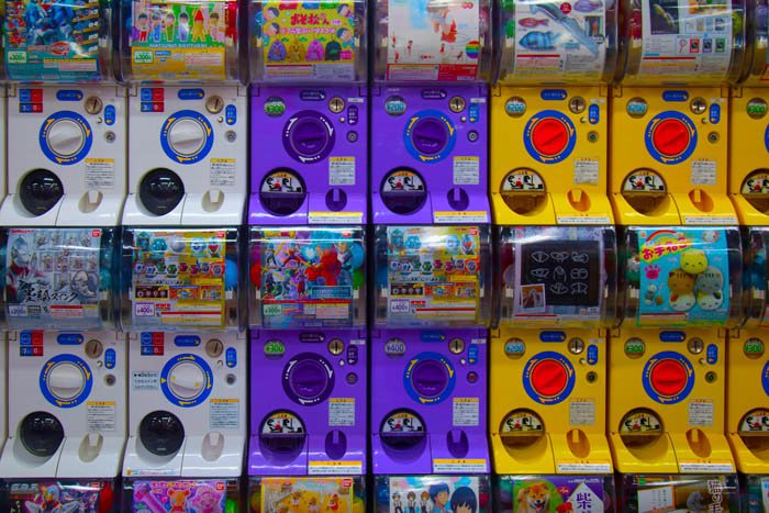Вдохновение уличной фотографии: Японские диспенсеры для игрушек расположены по цвету в узор: белый, фиолетовый, желтый