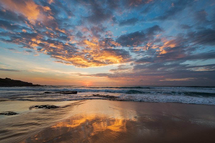 песок, отражающий закат на пляже в вечернее время