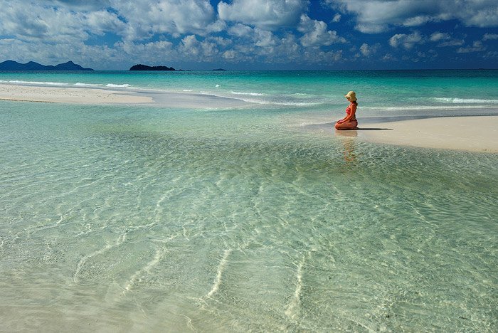 Девушка стоит на коленях на пляжном морском пейзаже в дневное время