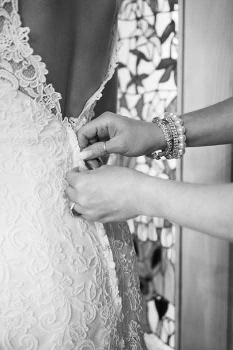Черно-белая свадебная фотография матери невесты, застегивающей свадебное платье