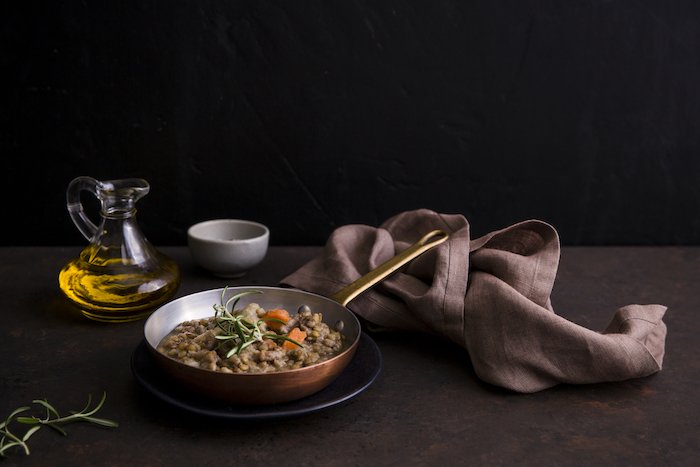 Натюрморт пищевой фотографии изображение чечевичный суп в медном горшке на столе