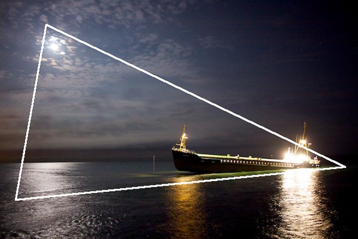 Фотография корабля в море ночью с наложенным композиционным треугольником - правила композиции фотографии