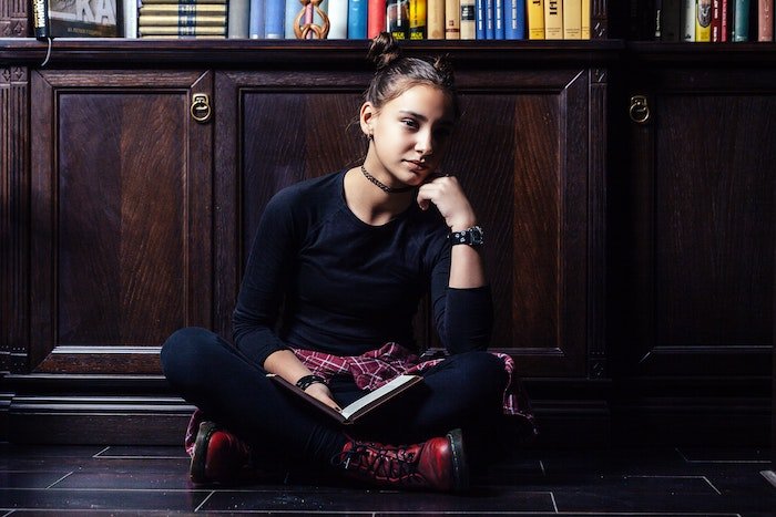 Автопортрет женщины, сидящей и читающей книгу в библиотеке