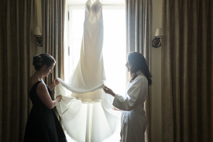 Две женщины осматривают свадебное платье