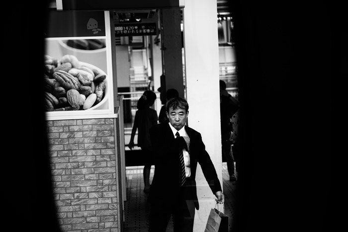 черно-белые фотографии мужчины в костюме, идущего по улице