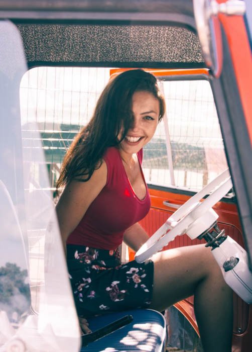 Женская фотомодель, сидящая на водительском сиденье автомобиля - композиция модной фотографии