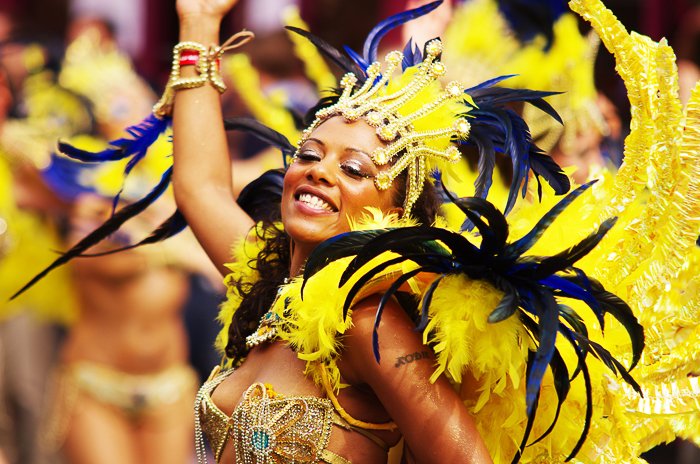 Портрет карнавальной танцовщицы в ярком желтом платье с перьями