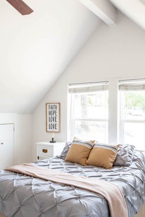 детальное фото постельного белья, окон и высокого потолка