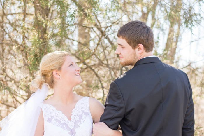 Свадебная поза жениха и невесты рука об руку на открытом воздухе