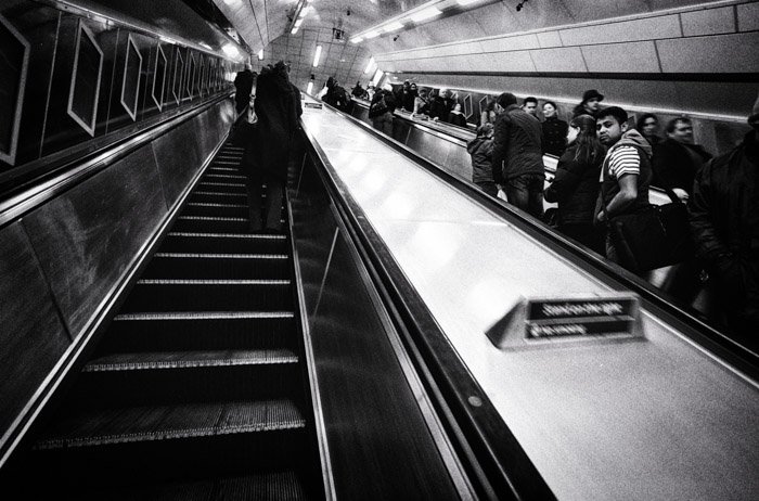 Черно-белое изображение людей в лифте станции метро