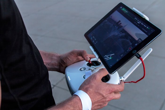 изображение мужчины, использующего планшет для управления дроном для пейзажной съемки 
