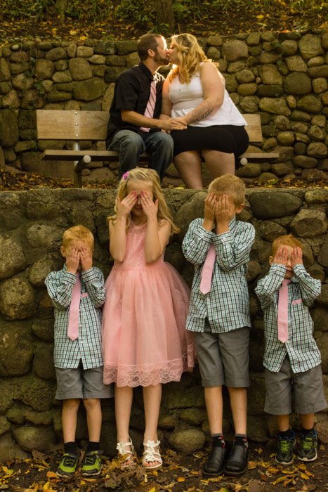 Cue семейное фото четырех детей, закрывающих глаза от целующихся позади них родителей