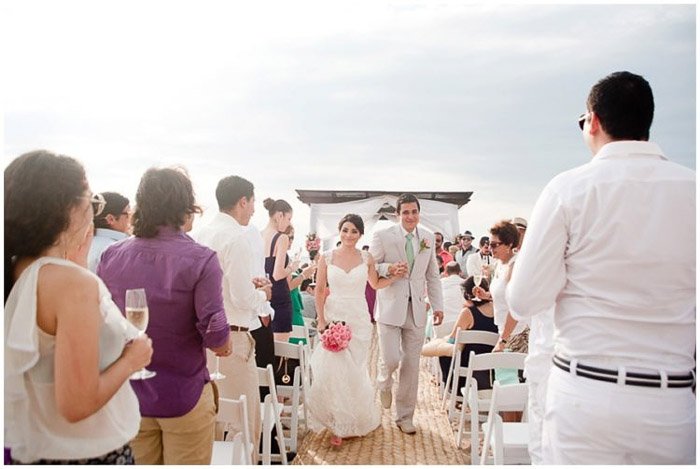 Молодожены идут к алтарю на пляжной свадьбе на открытом воздухе. Любительская свадебная фотография.