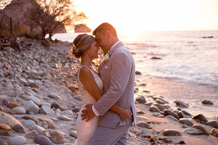 Мягкая мечтательная свадебная фотография молодоженов, обнимающихся на пляже. Любительская свадебная фотография