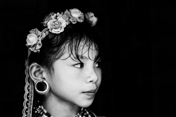 черно-белый туристический портрет молодой девушки с белыми цветами в волосах и традиционными украшениями