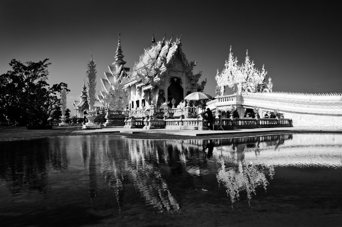 Черно-белая фотография Белого храма в Чианграе, Таиланд, здание отражается в воде внизу