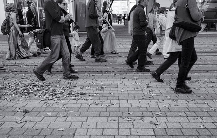 Черно-белая уличная фотография группы прогуливающихся людей. Креативная уличная фотография
