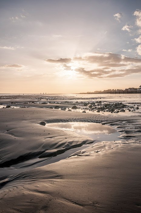 красивая фотография заката на песчаном, скалистом пляже, небо отражается в водных бассейнах