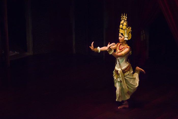 Атмосферная туристическая фотография девушки, танцующей в тускло освещенной комнате