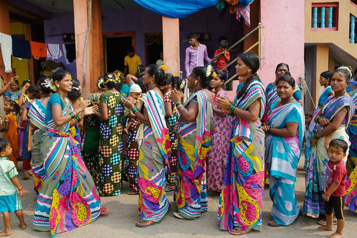 Путевая фотография группы красочно одетых женщин на улицах Индии. 