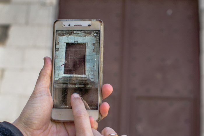 Использование смартфона для фотографирования оконной рамы на фотопрогулке