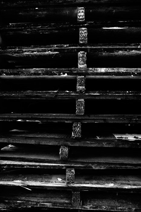 Теневая черно-белая фотография стопки деревянных паллет.