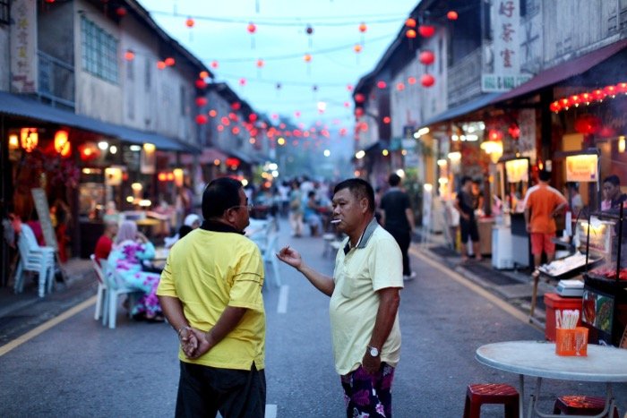 Документальная фотография двух мужчин, беседующих на оживленной улице
