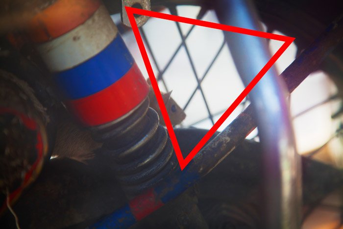 Фотография деталей машины крупным планом с красной треугольной диаграммой. Естественное кадрирование фотографии.