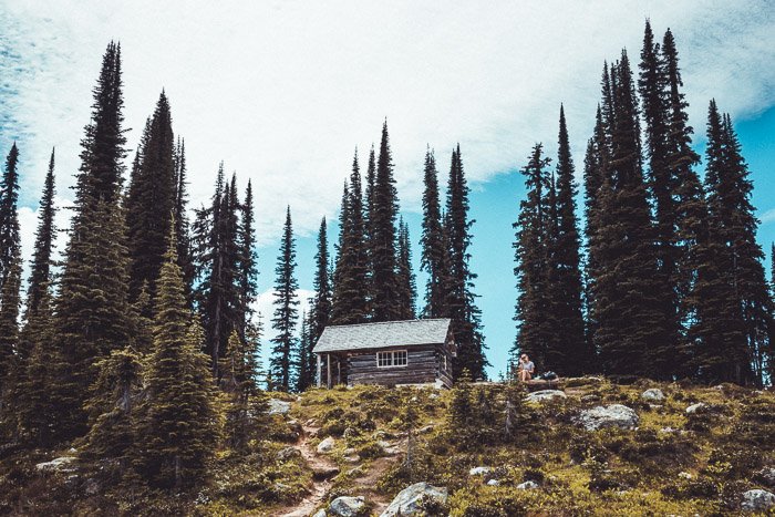 Яркая фотография домика на холме в окружении высоких деревьев - как заработать на фотографии путешествий